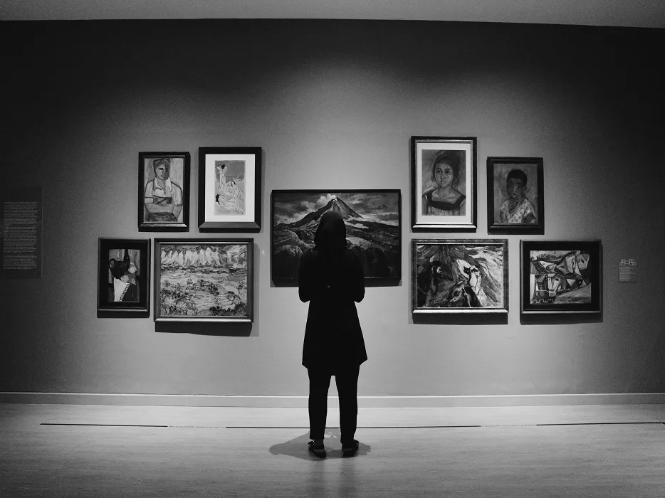 アートギャラリーで絵画鑑賞をする女性のシルエット