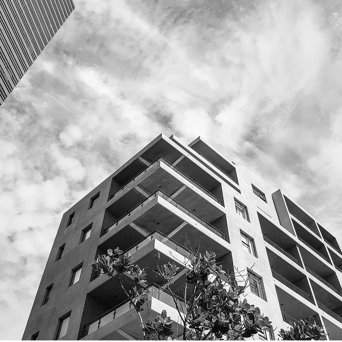 都市部での快適な暮らしを象徴するスタイリッシュな不動産物件の低アングルから見たバルコニー付き集合住宅外観