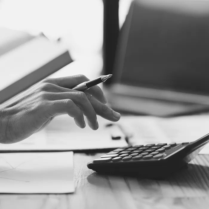 不動産管理で家賃収入を電卓で計算しながら資料を作成するビジネスパーソンの手元